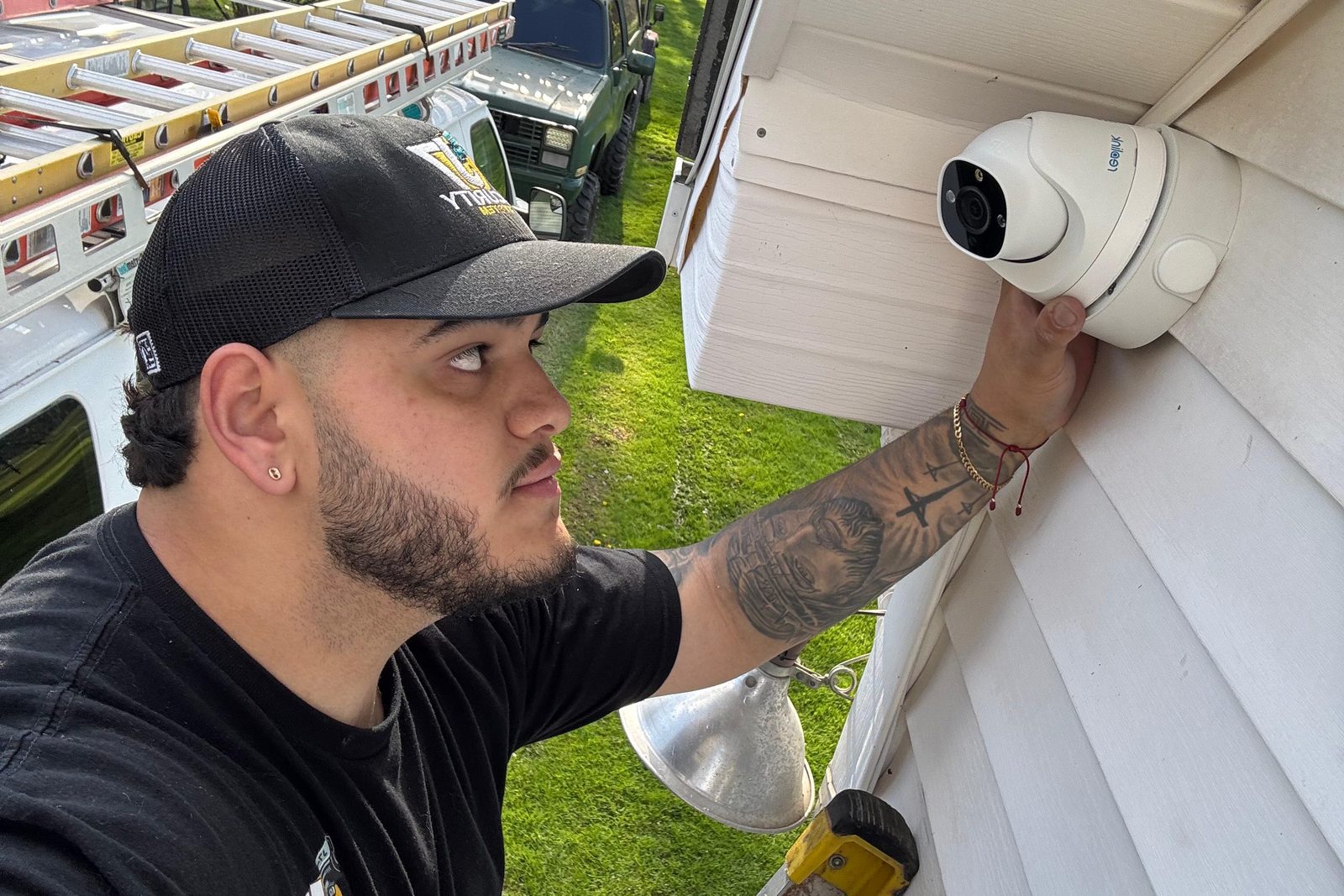 Technician mounting a turret camera under the eave of a New Jersey home